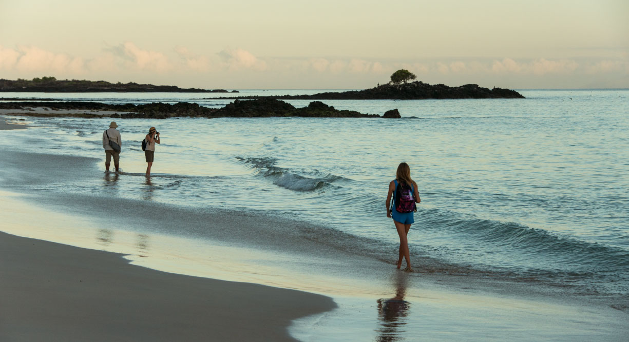 Bachas Beach - Santa Cruz in Galapagos Island beautiful white sand beach and tourist walking