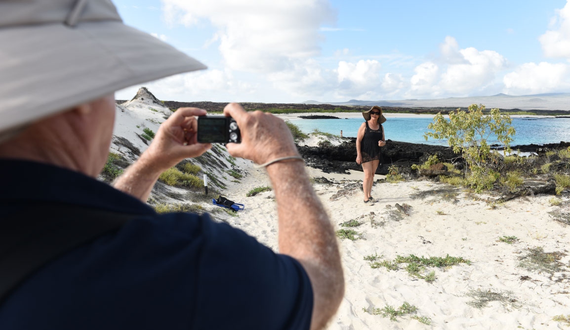 Cerro Brujo - San Cristobal in Galapagos Islands, tourist walking in the beach and watching the sea