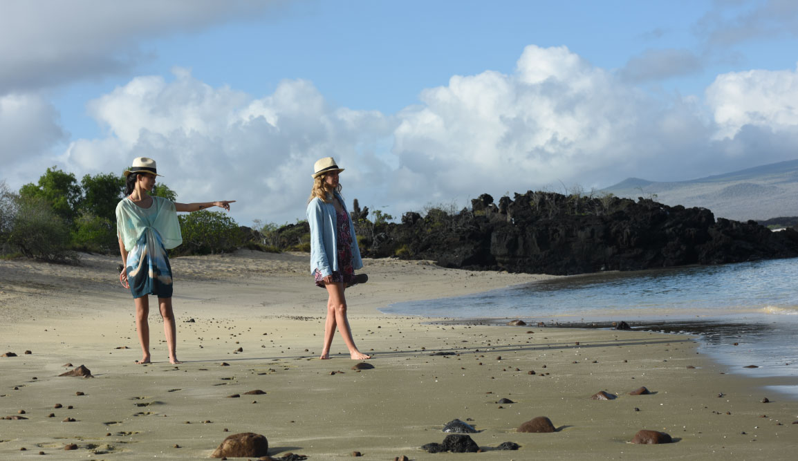 Cerro Brujo - San Cristobal in Galapagos Islands, tourist walking in the beach and watching the sea