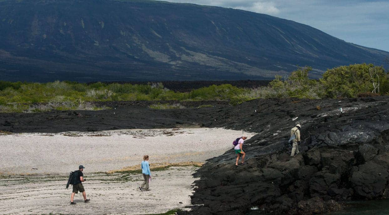 Espinoza Point landscape with rocky beach and volcanoes, hiking tourist