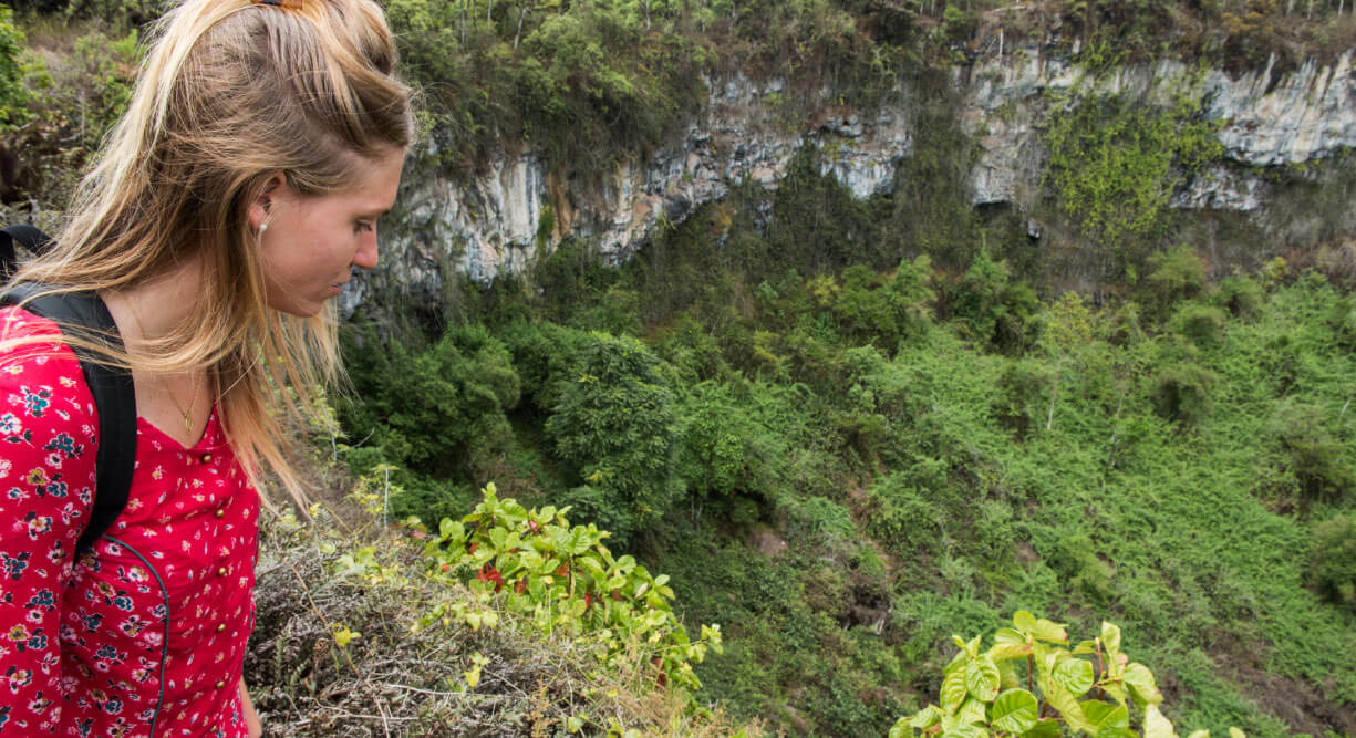 Highlands - Santa Cruz, in the Galapagos view of the crater with plants and girl tourist