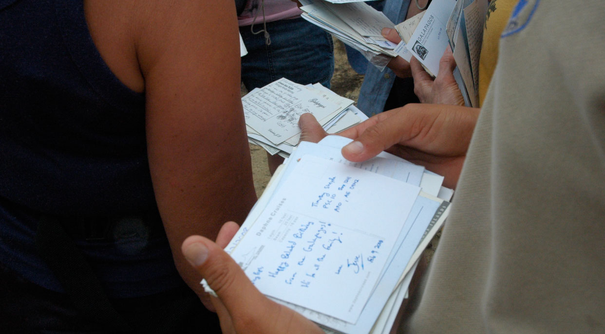 Post Office - Floreana Island in the Galapagos, tourist reading letters