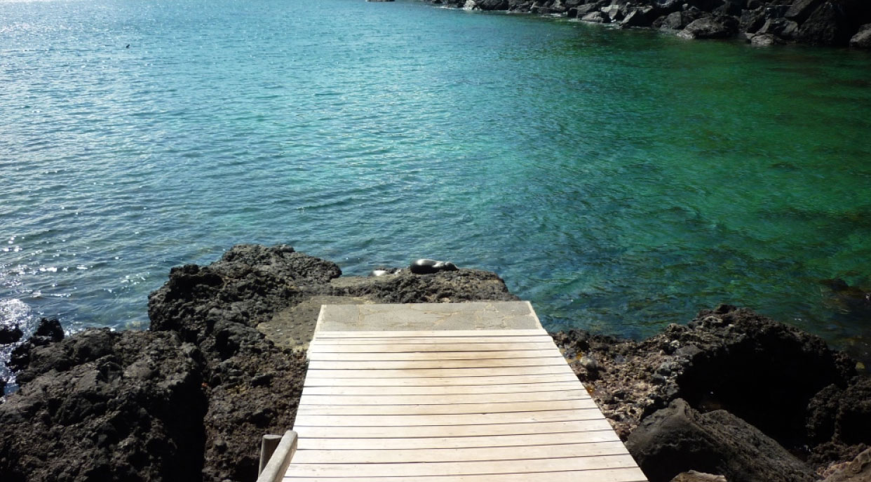 Interpretation Center and tijeretas - San Cristobal in Galapagos Islands view of the sea and the dock with rocks